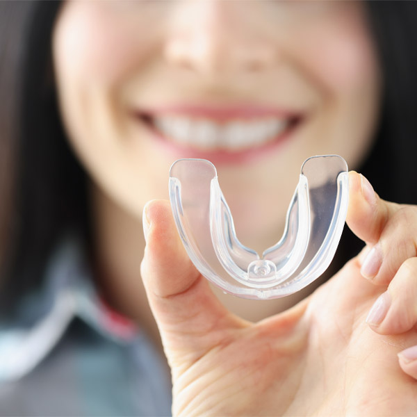 woman holding mouthguard