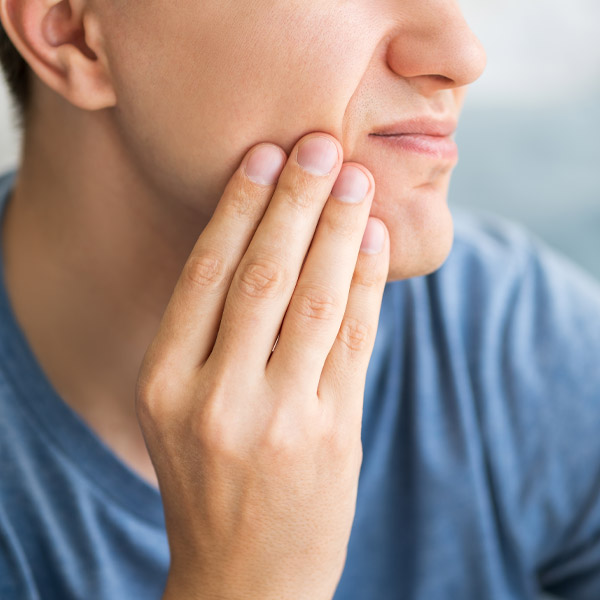 person holding their jaw in pain