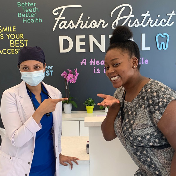 Dr. Monika and patient admiring the patients teeth at Fashion District Dental in Toronto