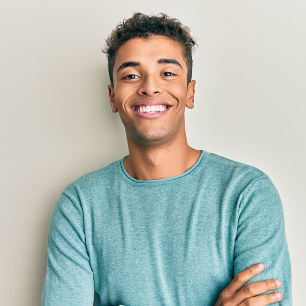 young adult male smiling with his arms crossed